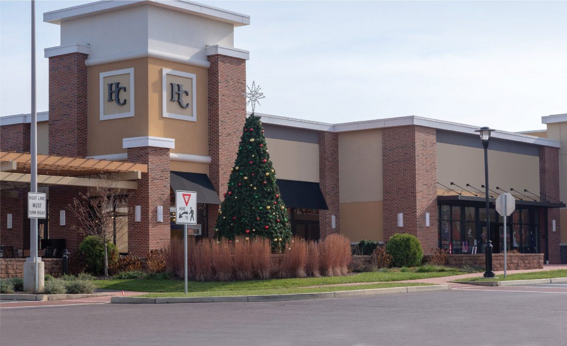 A shopping center with a Christmas tree in front