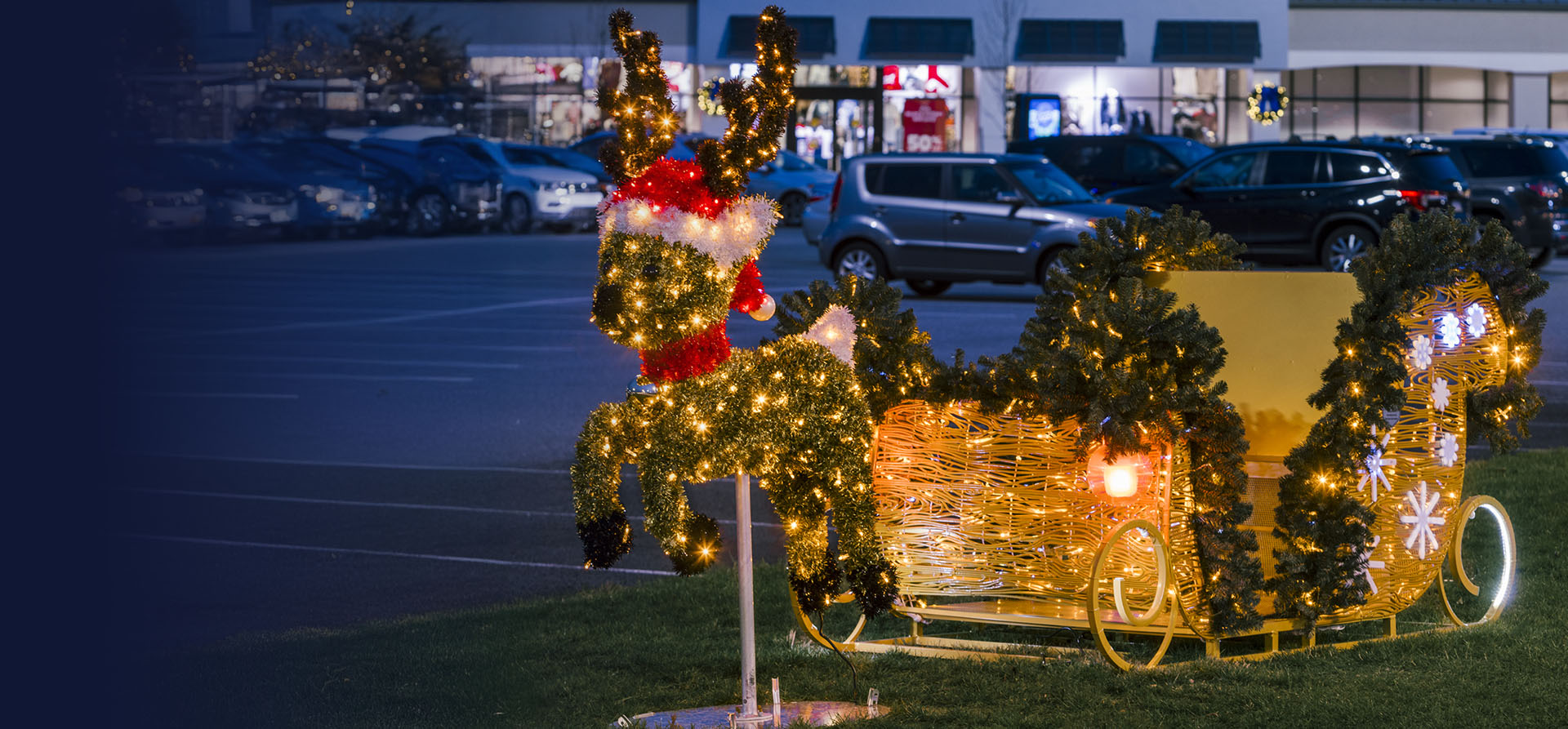 Sled with lights in front of Tanger Outlets with reindeer